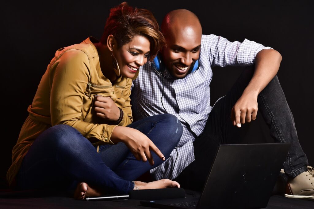 Adults looking at laptop and smiling