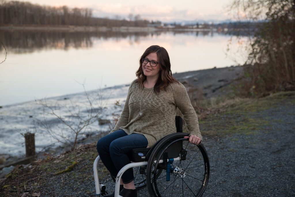 Woman in wheelchair along the bank of a lake